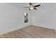 Simple bedroom with a window, ceiling fan and light wood flooring at 5049 Birdsong St, North Port, FL 34291