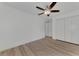 Simple bedroom with ceiling fan, double doors and light wood flooring at 5049 Birdsong St, North Port, FL 34291