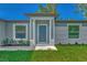 Modern gray front door with a covered entryway and landscaping at 5049 Birdsong St, North Port, FL 34291