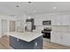 Modern kitchen with white cabinets, stainless steel appliances and an island at 5049 Birdsong St, North Port, FL 34291