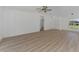 Spacious living area with light wood flooring and a ceiling fan at 5049 Birdsong St, North Port, FL 34291