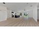 Open concept living room and kitchen with light wood floors and ceiling fan at 5049 Birdsong St, North Port, FL 34291