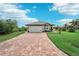 One-story house with gray roof and brick paver driveway at 102 Linda Lee Dr, Rotonda West, FL 33947