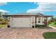 White house with gray roof, white garage door, and brick paver driveway at 102 Linda Lee Dr, Rotonda West, FL 33947