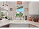 Modern kitchen with double sink, marble countertops, and a view of the backyard at 102 Linda Lee Dr, Rotonda West, FL 33947