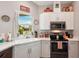 Updated kitchen featuring white shaker cabinets, stainless steel appliances, and a window overlooking the backyard at 102 Linda Lee Dr, Rotonda West, FL 33947