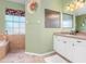 Bathroom with double vanity, large mirror, and a relaxing bathtub at 1020 Caliva St, North Port, FL 34286