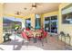 Covered patio with painted mural, dining area and ceiling fans at 1020 Caliva St, North Port, FL 34286