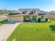 Beautiful yellow house with a two-car garage and well-manicured lawn at 1020 Caliva St, North Port, FL 34286