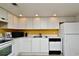 White kitchen cabinets, black appliances and yellow accent wall at 1051 Forrest Nelson Blvd # 203, Port Charlotte, FL 33952