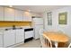 Small kitchen with white cabinets, yellow accent wall, and table at 1051 Forrest Nelson Blvd # 203, Port Charlotte, FL 33952