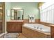 Elegant bathroom with a corner soaking tub and double vanity at 13147 Preserve Ct, Port Charlotte, FL 33953