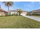 Single-story home with landscaped lawn, driveway, and two palm trees at 13147 Preserve Ct, Port Charlotte, FL 33953