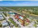 Aerial view of a clubhouse featuring a pool, tennis courts, and lush green spaces at 136 Seaward Way, North Port, FL 34287