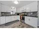 Kitchen area showcasing white cabinets, sleek countertops, and stainless steel appliances at 136 Seaward Way, North Port, FL 34287