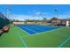 Bright blue tennis court with green surround for an active lifestyle at 136 Seaward Way, North Port, FL 34287