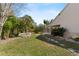 Lush backyard with tropical plants, a small patch of grass, and a screened-in porch at 154 Catamaraca Ct, Punta Gorda, FL 33983