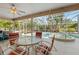 Outdoor patio with a ceiling fan, table, chairs, and a clear view of the pool and lush greenery at 154 Catamaraca Ct, Punta Gorda, FL 33983