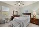 Cozy bedroom with a queen-size bed, wood dresser, and ceiling fan at 17638 Palmetto Pass Ln, Punta Gorda, FL 33982