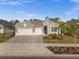 Two-story house with light beige exterior, two-car garage, and landscaping at 17638 Palmetto Pass Ln, Punta Gorda, FL 33982