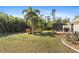 Expansive backyard showcasing palm trees, a patio, and well-manicured lawn at 1785 Nagorsky Ave, North Port, FL 34288