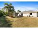 Large backyard with a white house, palm trees, and a grassy lawn at 1785 Nagorsky Ave, North Port, FL 34288