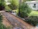 Brick pathway meanders through a garden landscape in the backyard at 18085 Wintergarden Ave, Port Charlotte, FL 33948