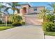 Two-story house with a peach-colored facade, two-car garage, and lush landscaping at 1811 Scarlett Ave, North Port, FL 34289