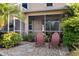 Stone patio with red chairs and landscaping at 1811 Scarlett Ave, North Port, FL 34289