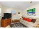 Living room with a beige sofa, wicker chairs, and a TV at 1956 Wyoming Ave # 0, Englewood, FL 34224