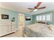 Main bedroom with ceiling fan, large TV, and ensuite bathroom at 2358 El Cerito Ct, Punta Gorda, FL 33950