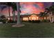 Beautiful waterfront home at sunset, featuring a landscaped yard and palm trees at 2358 El Cerito Ct, Punta Gorda, FL 33950