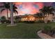 Tan single-story home with lush landscaping at sunset at 2358 El Cerito Ct, Punta Gorda, FL 33950