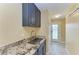 Laundry room with granite countertop, utility sink, and built-in cabinets at 2358 El Cerito Ct, Punta Gorda, FL 33950