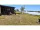 Landscaped backyard with lake view, screened porch and American flag at 25281 E Lenox Cir, Punta Gorda, FL 33950