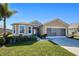 House exterior features a two-car garage and landscaped yard at 25281 E Lenox Cir, Punta Gorda, FL 33950