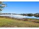 Serene view of a lake with lush greenery and houses in the background at 25281 E Lenox Cir, Punta Gorda, FL 33950