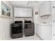 Bright laundry room with washer, dryer, and cabinets at 2748 Saint Thomas Dr, Punta Gorda, FL 33950