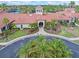 Beautiful clubhouse features a red tile roof, manicured landscaping, and an inviting entrance, enhancing community appeal at 2860 Arugula Dr, North Port, FL 34289