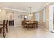 Neutral dining room features a wooden table, six chairs, and a window with plantation shutters at 2860 Arugula Dr, North Port, FL 34289