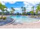 Resort-style community pool featuring clear blue water, palm trees, and ample seating, creating an inviting oasis for relaxation at 2860 Arugula Dr, North Port, FL 34289