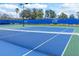 Well-maintained tennis court with blue and green surface, surrounded by fencing at 2860 Arugula Dr, North Port, FL 34289