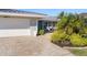 House exterior showcasing a paved driveway, attached garage, and lush landscaping at 2871 Coral Way, Punta Gorda, FL 33950