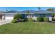 Single-story home with a metal roof, landscaping, and a paved driveway at 2871 Coral Way, Punta Gorda, FL 33950