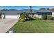 House exterior featuring a metal roof, white garage door, and landscaped yard at 2871 Coral Way, Punta Gorda, FL 33950