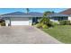 Landscaped front yard with paver driveway and teal front door at 2871 Coral Way, Punta Gorda, FL 33950
