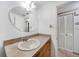 Simple bathroom with oval mirror, single sink vanity, and linen closet at 3360 Conway Blvd, Port Charlotte, FL 33952