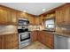 Well-equipped kitchen with wood cabinets, stainless steel appliances, and tile floor at 3360 Conway Blvd, Port Charlotte, FL 33952