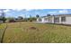 Large backyard with grassy lawn and distant views of neighboring homes at 3429 Sleepy Hollow Ln, Punta Gorda, FL 33950