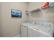 Functional laundry room equipped with modern machines, shelving, and decor for organized efficiency at 43306 Water Bird Way # 6622, Punta Gorda, FL 33982